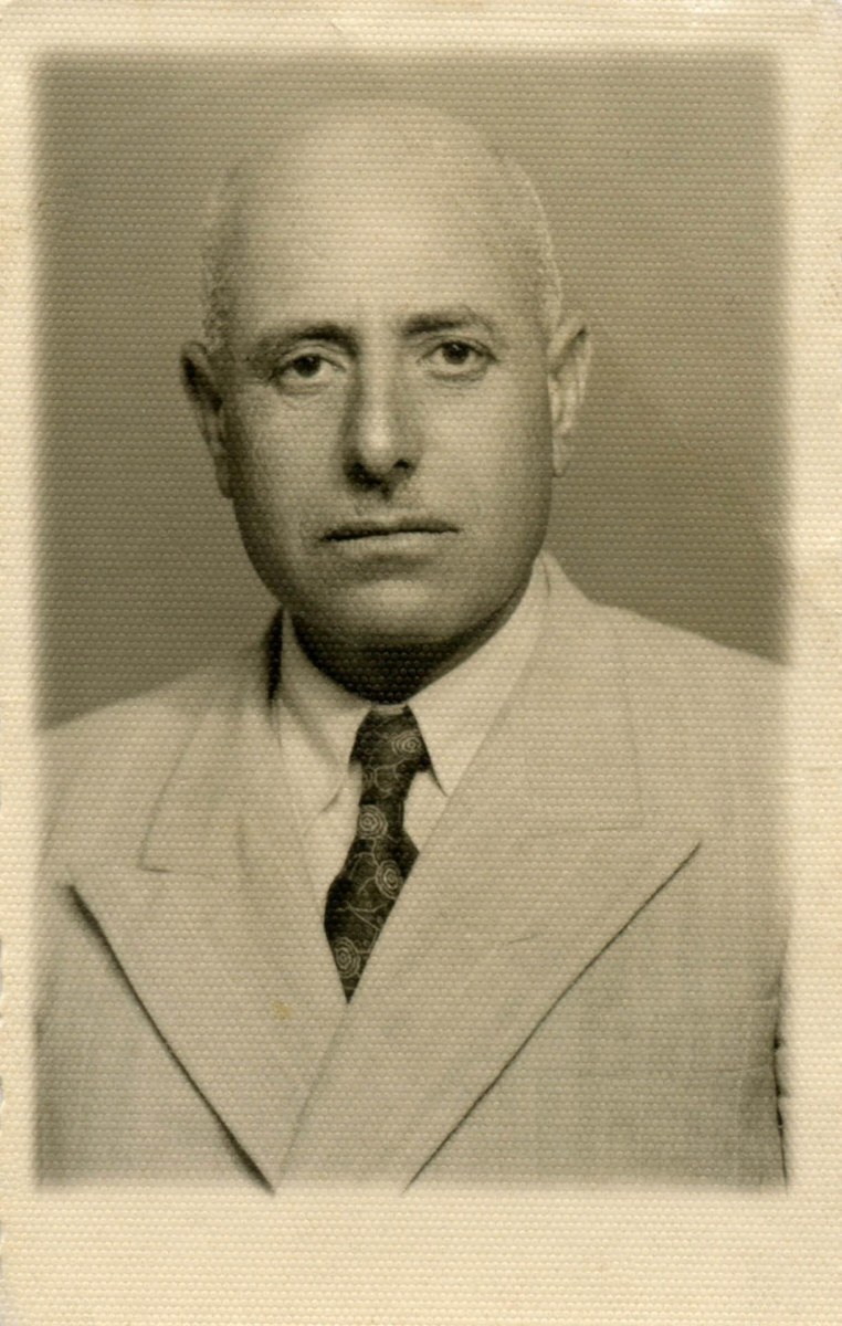 A man of about thirty-four in a light suit and a patterned tie, in a sepia studio portrait